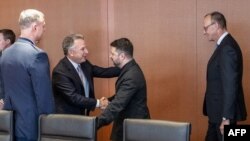 Специалният пратеник на САЩ Стив Уиткоф и украинският президент Володимир Зеленски (в центъра) в Берлин, 14 декември 2025 г. Германският канцлер Фридрих Мерц е отдясно на Зеленски.