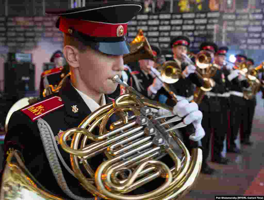 Far from the main stage, military cadets play in a marching band.