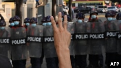 Протестиращ в Мианмар поздравява полицията със знак с три пръста, който се превърна в символ на съпротивата срещу военните