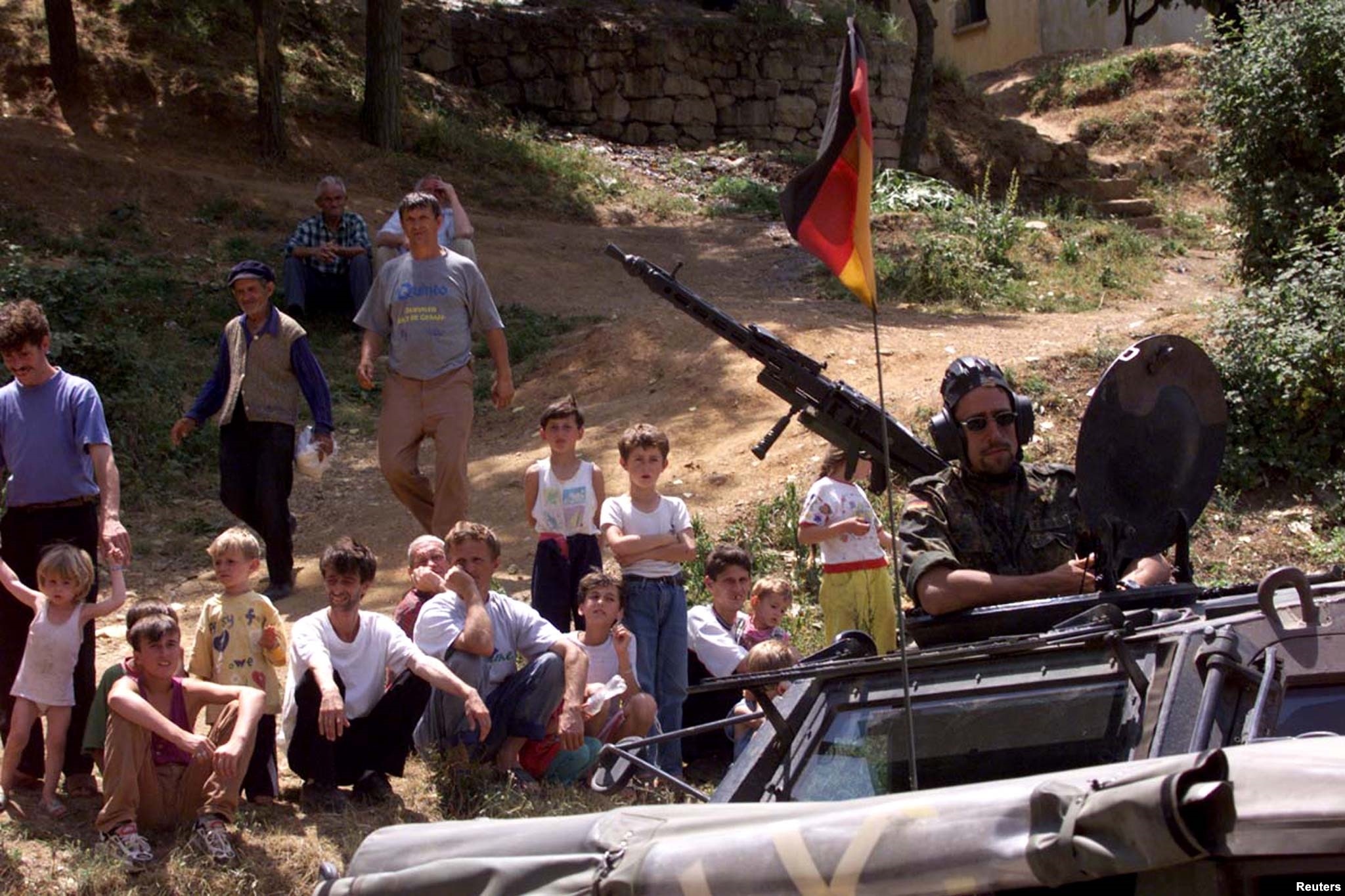 Një ushtar gjerman përcillet nga një grup refugjatësh kosovarë në Kukës të Shqipërisë, prej ku trupat do të niseshin drejt Kosovës, për ta hapur rrugën e kthimit të qindra mijëra refugjatëve.