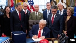 US President Donald Trump signs a funding bill in the Oval Office of the White House in Washington, DC, on February 3, 2026.