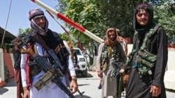 AFGHANISTAN -- Taliban fighters stand guard along a roadside near the Zanbaq Square in Kabul on August 16, 2021
