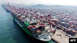 O navă de marfă și containere, într-un port din Qingdao, provincia Shandong din estul Chinei, pe 10 martie 2026.