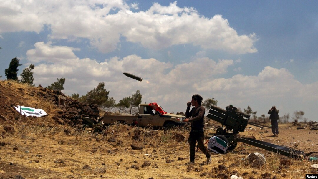 Free Syrian Army rebel fighters fire rockets towards government forces in the northern countryside of Quneitra in June this year. 