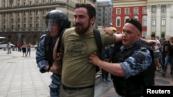 Police detain Dmitry Tsorionov, known by the nickname Dmitry Enteo, leader of the Orthodox group God's Will, after his supporters fought with gay-rights activists during an LGBT community rally in central Moscow on May 30.