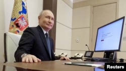 Russian President Vladimir Putin casts his vote online in the presidential election on March 15. By all estimates, the repression of dissenting voices will only increase in the wake of Putin's reelection. 