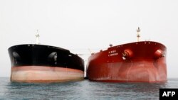 A picture taken on March 12, 2017, shows an Iranian tanker and a South Korean (R) tanker docking at the platform of the oil facility in the Khark Island, on the shore of the Gulf.