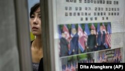 Phenýan. Metro stansiýasynda täzelikleri okaýan aýal. Arhiw suraty