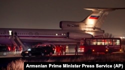 ARMENIA -- People stand at a Russian military plane with some of Armenian captives upon its arrival at a military airport outside Yerevan, December 14, 2020
