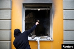 Një person gjuan gur drejt ndërtesës së Ministrisë së Arsimit. Tiranë, 14 tetor 2026.