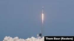 Ракета Falcon 9 с космическим кораблем Crew Dragon с двумя астронавтами на борту взмывает в небо с космодрома на мысе Канаверал во Флориде. 30 мая 2020 года.