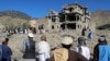 Afghan residents look at the remains of a building damaged in a Pakistani air strike at a village in Tsamkani District of Afghanistan's Paktia Province on June 29.
