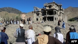 Afganistanci gledaju ostatke zgrade oštećene u pakistanskom vazdušnom napadu na selo u okrugu Camkani u afganistanskom pokrajini Paktija 29. juna.