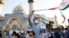 Supporters of Iranian presidential candidate Ebrahim Raisi hold pictures depicting him during an election campaign rally in Tehran, on June 16.