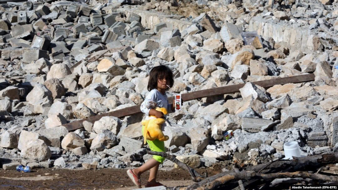 An Iranian child walks on the rubble of a collapsed house after an earthquake in the western Kermanshah Province on November 15.