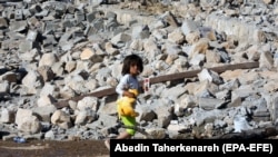 An Iranian child walks on the rubble of a collapsed house after an earthquake in the western Kermanshah Province on November 15.