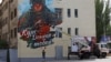 Painter Vladislav Stepnoy works on his mural reading "Kursk, Donetsk is with you!" in support of residents of Russia's Kursk region, on the facade of a building in Donetsk, Russian-controlled Ukraine.