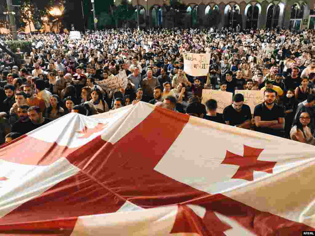 A large crowd carries a Georgian flag on June 21.&nbsp;