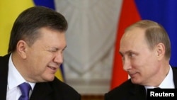 Russia -- Ukrainian President Viktor Yanukovych (L) gives a wink to his Russian counterpart Vladimir Putin during a signing ceremony after a meeting of the Russian-Ukrainian Interstate Commission at the Kremlin in Moscow, December 17, 2013