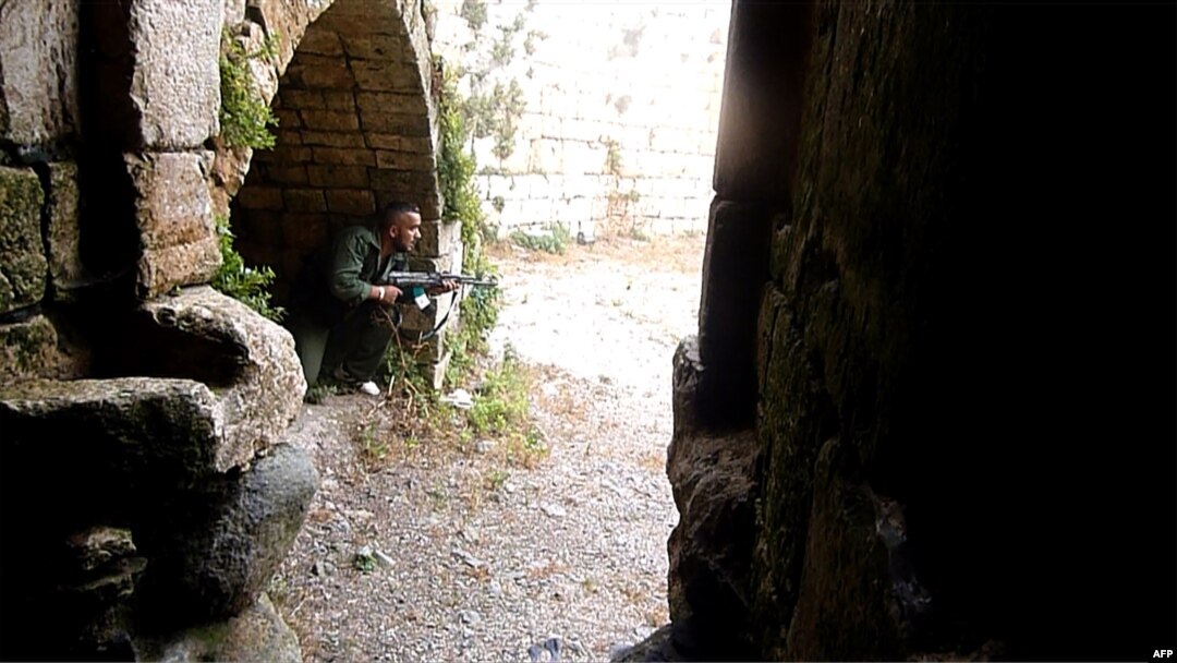 A Syrian rebel takes a position at the Crac des Chevaliers near the village of Azzara on the outskirts of the flashpoint city of Homs.