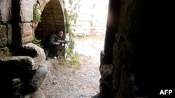 A Syrian rebel takes a position at the Crac des Chevaliers near the village of Azzara on the outskirts of the flashpoint city of Homs.