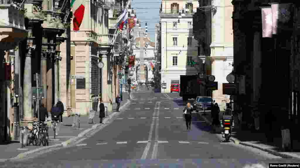 italy - People walk in an almost empty Via del Corso, as Italy tightens measures to try and contain the spread of coronavirus disease (COVID-19), in Rome, 23Mar2020