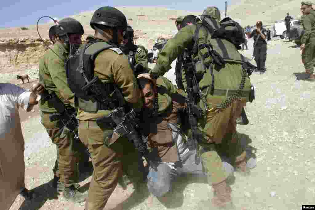 Israeli soldiers detain a Palestinian man during scuffles following an attempt by European diplomats to deliver goods to locals in the West Bank herding community of Khirbet al-Makhul. (Reuters/Abed Omar Qusini)