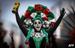 Një grua e veshur si Catrina mban një kopje të trofeut të Kupës së Botës, në Meksiko Siti, qershor 2026.