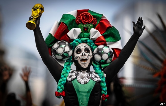 Një grua e veshur si Catrina mban një kopje të trofeut të Kupës së Botës, në Meksiko Siti, qershor 2026.
