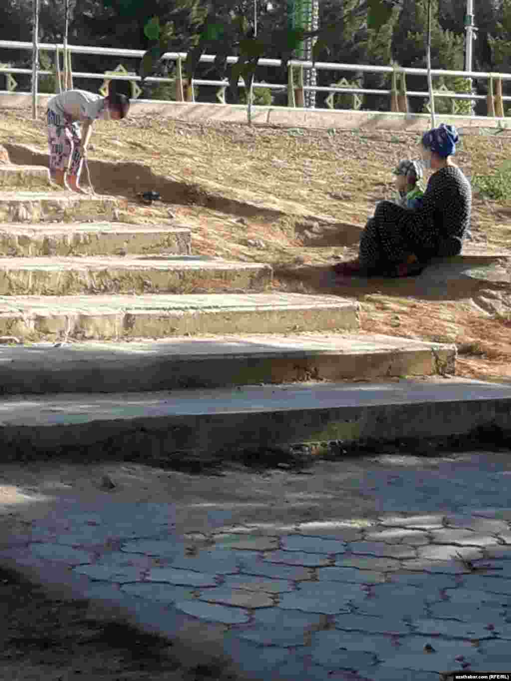 Aşgabat. Daşarda çagalary bilen dynç alýan aýal. Awgust, 2020.