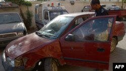 A Pakistani police officer inspects a vehicle in which a woman identified as a U.S. national was shot in Karachi on April 16.