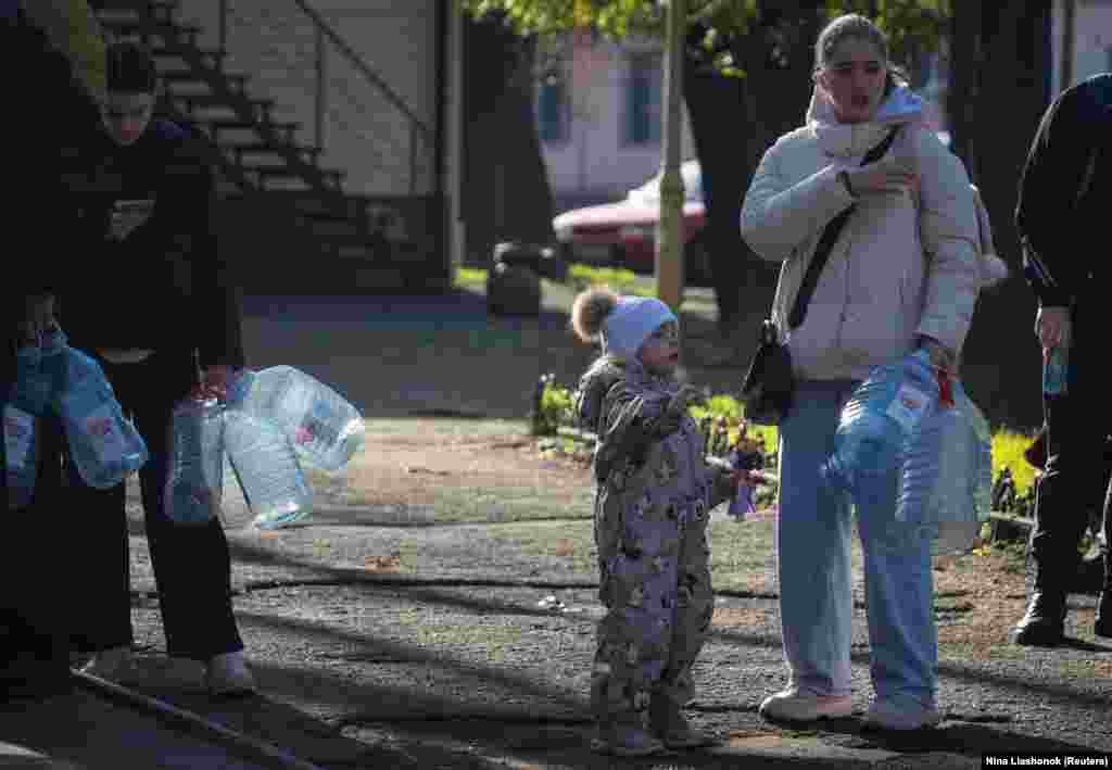 Одесити дорослі і маленькі стоять у черзі, щоб наповнити пляшки питною водою після того, як внаслідок атаки Росії була пошкоджена критично важлива цивільна інфраструктура міста, про що повідомила українська влада. Одеса, 13 грудня 2025 року