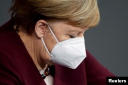 Cancelarul german Angela Merkel poartă o mască de protecție după ce a ținut un discurs despre răspunsul guvernului la pandemia de coronavirus, în parlamentul țării, Bundestag - la Berlin / Germania, 26 noiembrie 2020