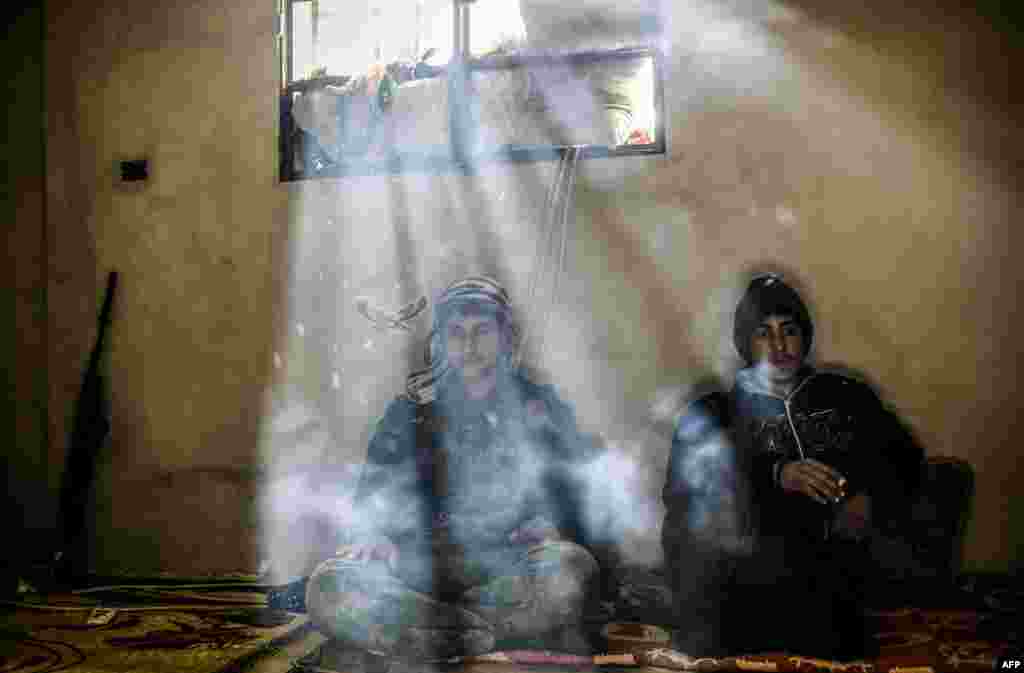 Kurdish fighters rest in a house on the outskirts of the Syrian town of Kobani. (AFP/Yasin Akgul)