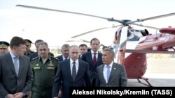 Президент Росії Володимир Путін (другий справа), міністр оборони Росії Сергій Шойгу (другий зліва), президент Республіки Татарстан Рустам Мінніханов (праворуч) та інші чиновники відвідують Казанський авіаційний завод у місті Казань, Татарстан, 13 травня 2019 року