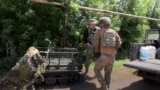 Ukrainian soldiers load ammunition and critical supplies onto a fibre-optic ground drone for frontline delivery.