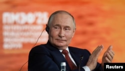 Владимир Путин Санкт-Петербургтегі Халықаралық экономикалық форумның пленарлық сессиясында қол соғып отыр. 20 маусым 2025 жыл.
