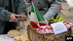 Un coș pe care scrie „100% produs italian” la proteste ale fermierilor italieni împotriva acordului de liber schimb UE-Mercosur, lângă clădirea administrației regiunii Lombardia, la Milano, pe 9 ianuarie 2026. Italia a semnat acordul după o lună de opoziție.