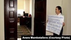 Анара Мамбеталиева в здании Госэкотехинспекции вышла на акцию с плакатом в руках.
