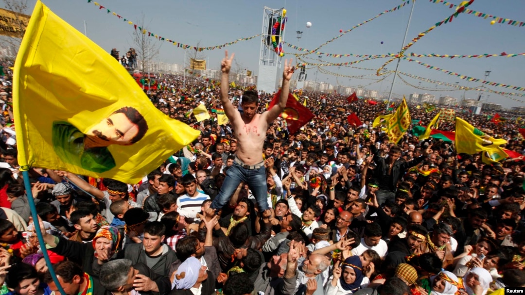 Demonstrators hold Kurdish flags and portraits of jailed Kurdistan Workers Party (PKK) leader Abdullah Ocalan during a gathering to celebrate Norouz in the southeastern Turkish city of Diyarbakir on March 21, 2013.