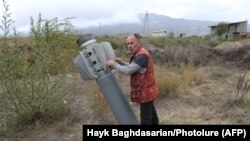NAGORNO-KARABAKH -- A man touches the remains of a rocket shell in a Karabakh town, October 1, 2020