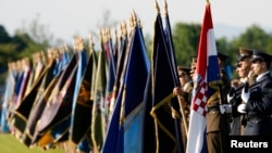 Karlovački gradonačelnik Damir Mandić kaže da su i druga dva mosta na ulazu u Karlovac nazvana po postrojbama koje su 1991. branile grad (fotografija: zastave hrvatskih postrojbi na paradi u Karlovcu 2009. godine)