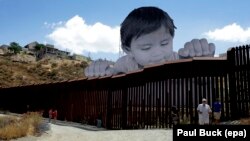 Ілюстрацыйнае фота. Інсталяцыя францускага мастака JR ля сьцяны, якая падзяляе Мэксыку і Каліфорнію