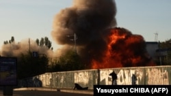 A man falls on the ground following a drone attack in Kyiv on October 17. Ukraine says Russia has struck its infrastructure with Iranian-made Shahed-136 drones that cruise toward their target and explode on impact. 