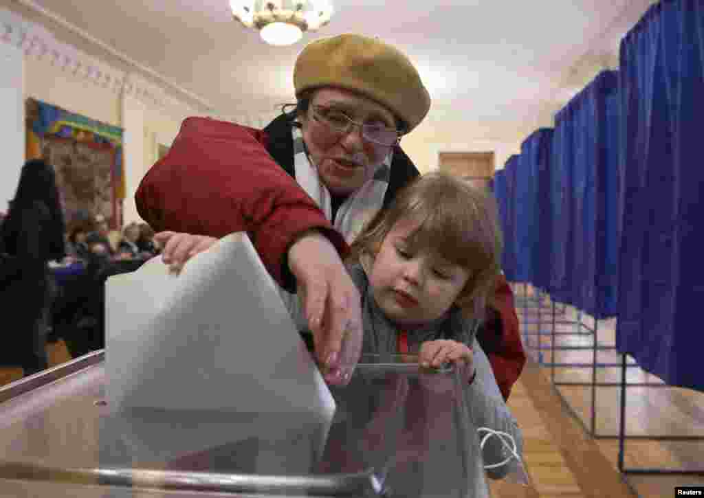 Жінка та дитина на виборчій дільниці у Києві