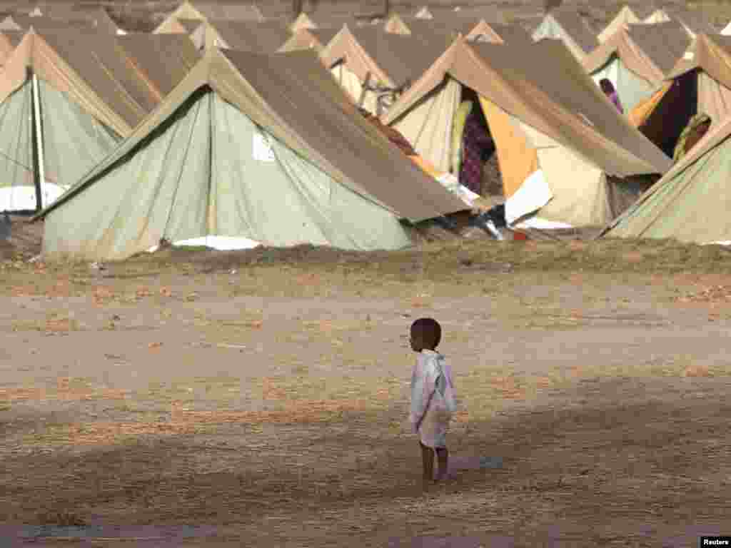 A boy who has been displaced by floods stands outside tents while taking refuge with his family in a relief camp for flood victims in Kakar, some 26 kilometers from Dadu in Pakistan's Sindh Province, on October 13.Photo by Akhtar Soomro for Reuters