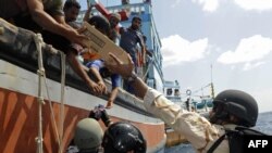 Sailors from the "U.S.S. Dewey" provide food, water and medical supplies to distressed Iranian mariners aboard the "Al Mamsoor" in the Arabian Sea on January 18.