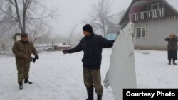 Учак бөлүктөрүн кармап турган адистер.