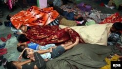 Indian border villagers sleep as they take shelter inside a community hall at RS Pura village, about 25 km from Jammu, the winter capital of Kashmir on October 9, 2014.