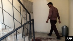 A man walks past bloodstains at the site of the killing of two alleged Al-Qaeda operatives by Pakistani security forces in Karachi in August 18.